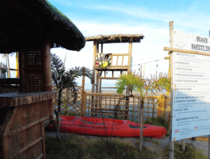 First-Time Kayakers at Beach Camp: A heartwarming image of beginners learning to kayak, with instructors guiding them, demonstrating Beach Camp's commitment to safe and enjoyable experiences for all skill levels.