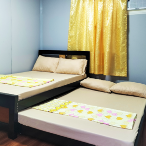 A close-up of the Clean Rooms Beach Resort's attention to detail in maintaining cleanliness. The image highlights a bedside table equipped with a sanitized phone and a lamp, both free of fingerprints or dust. The adjacent wall and floor are spotless, exemplifying the resort's rigorous cleaning protocols and dedication to guest comfort and health.