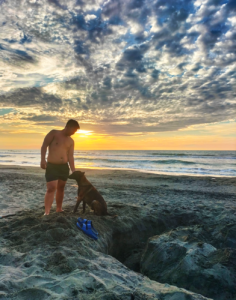 As the sun dips below the horizon at Beach Camp, casting the sky in a brilliant array of oranges, pinks, and purples, a customer stands at the water's edge, immersed in the breathtaking beauty of La Union's sunset. The golden light reflects off the gentle waves, creating a path of shimmering light that leads to the silhouette of the lone figure. With their feet buried in the soft, warm sand, the customer gazes out towards the vast, tranquil ocean, a look of awe and peace on their face. This solitary moment captures the essence of Beach Camp's serene environment—where guests can find solitude and connection with nature amidst the stunning backdrop of the Philippine coast. The scene is a testament to the unforgettable experiences and the tranquil escape Beach Camp offers, where every sunset is a reminder of the day's simple pleasures and the promise of another beautiful day to come.